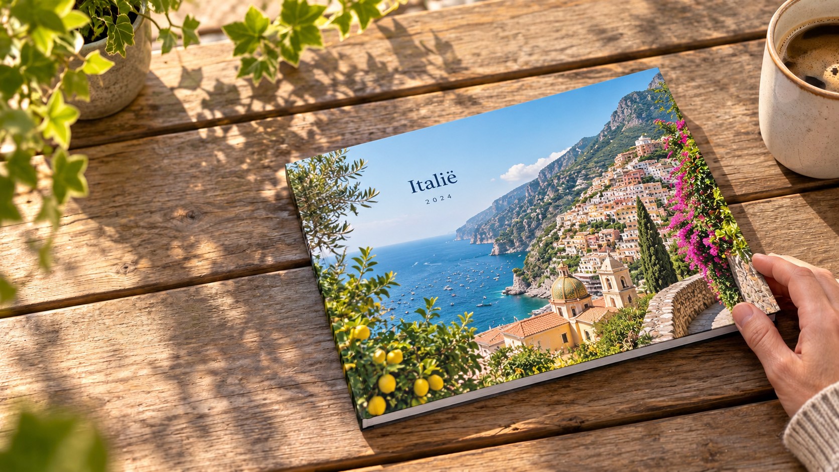 A5-fotoboek met de Italiaanse Amalfikust op de omslag, vastgehouden op een houten tafel