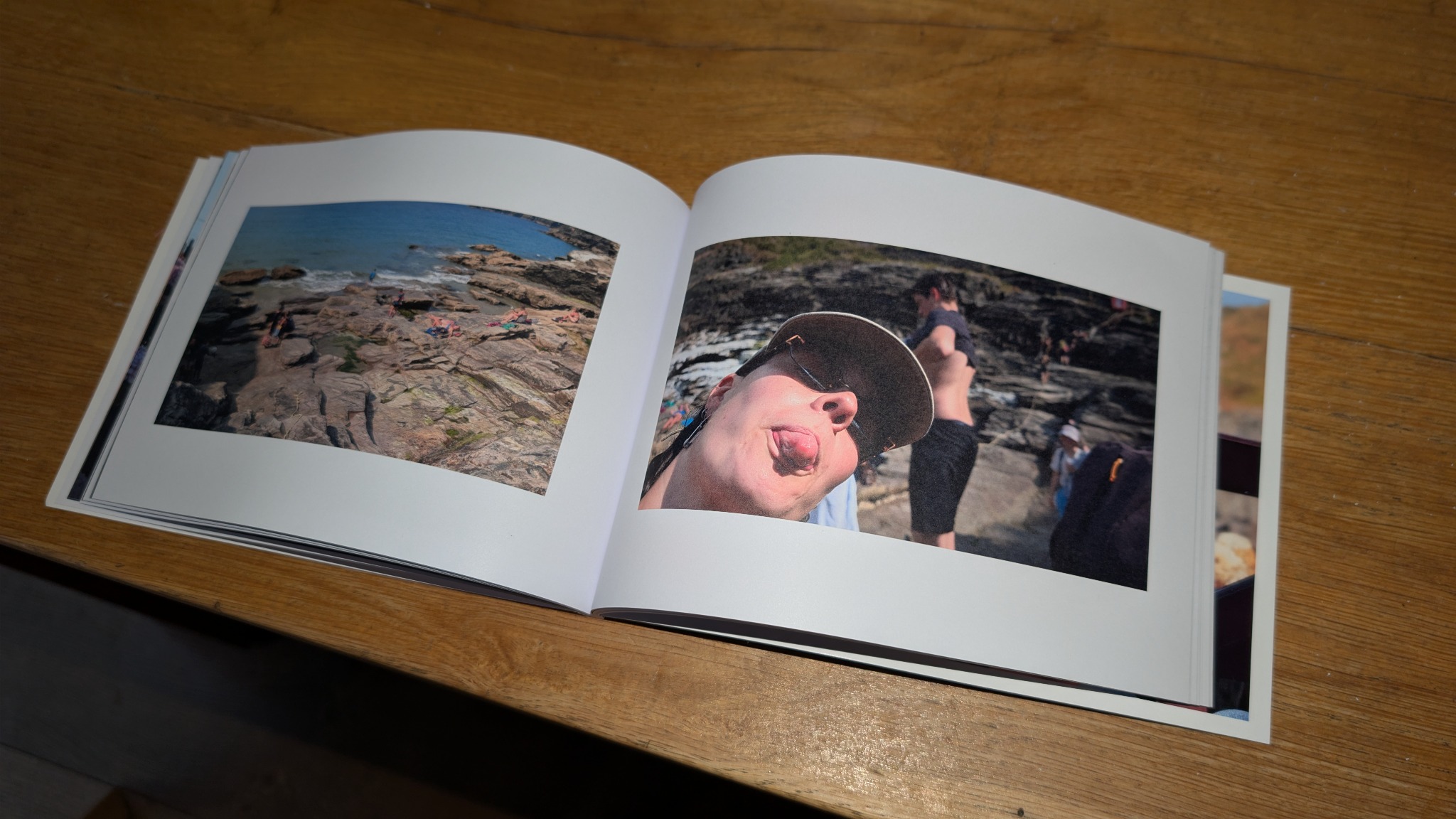 Een open gedrukt vakantiefotoboek met eigen reisbeelden op een houten tafel